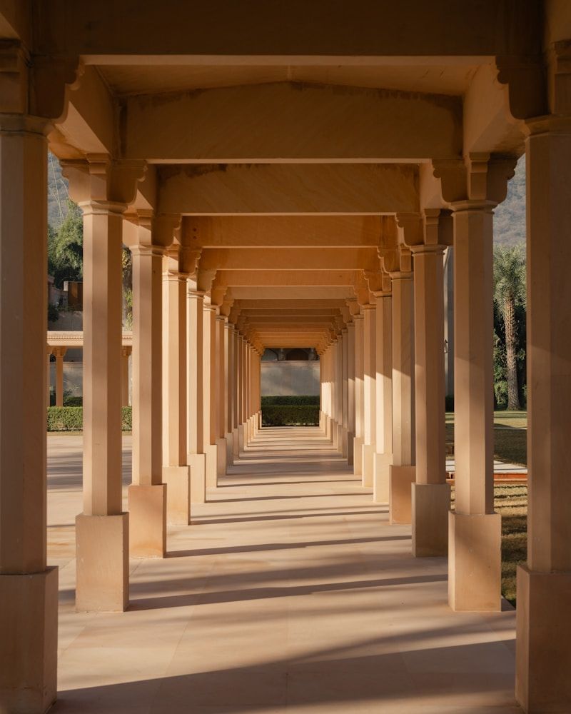 Sandstone colonnade with patterned sunlight and shadows