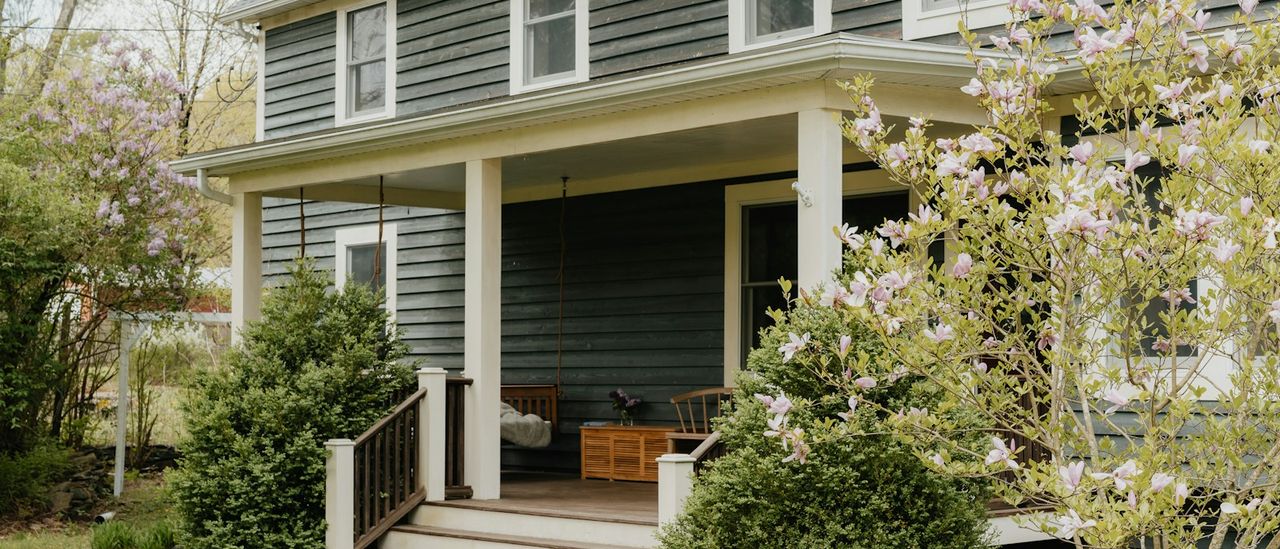 House porch with steps leading to the front door, spring shrubs in bloom