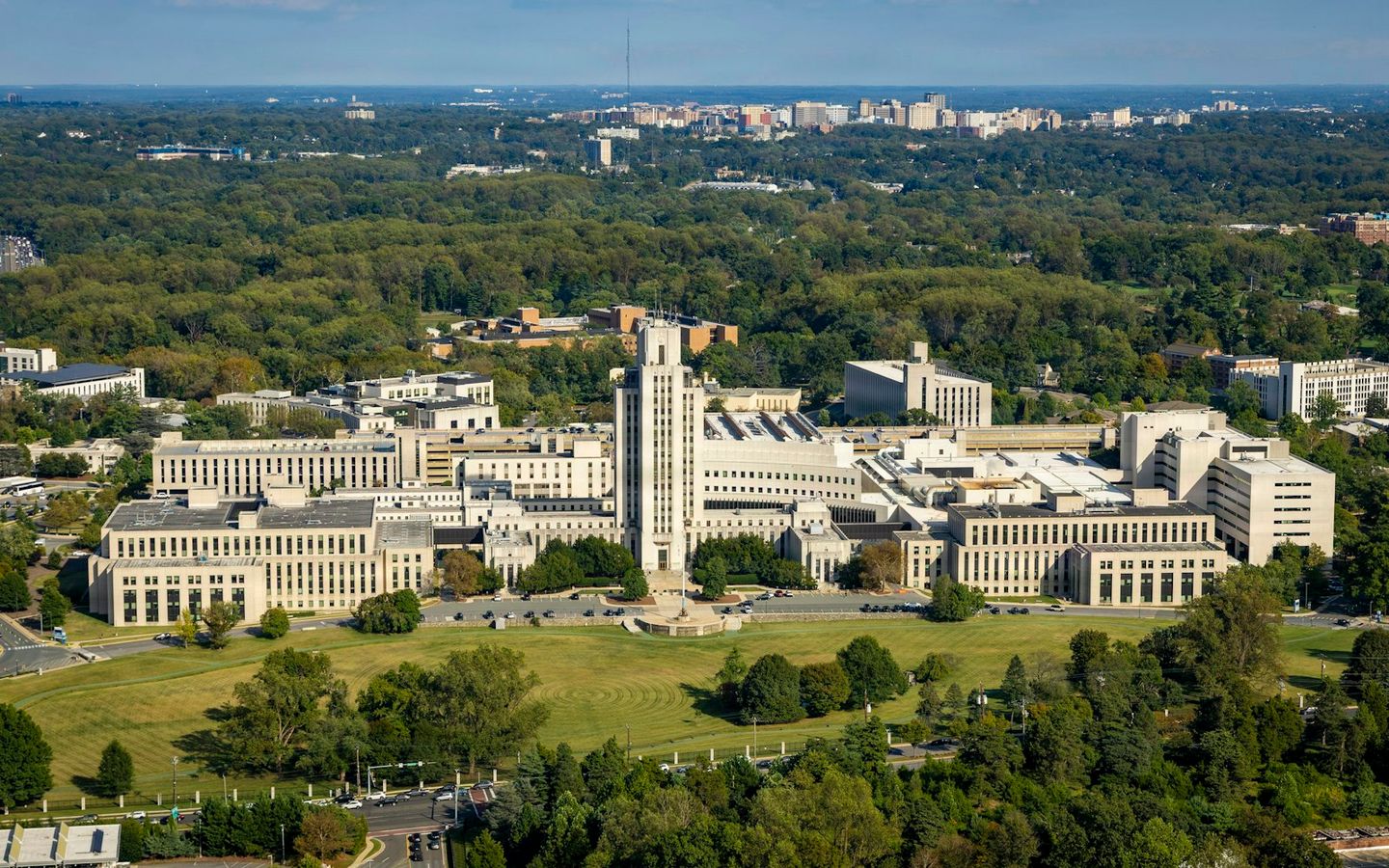 Aerial view of a large medical campus surrounded by green trees