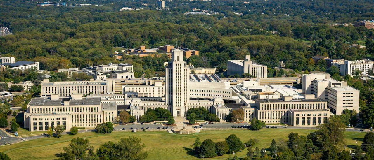 Aerial view of a large medical campus surrounded by green trees