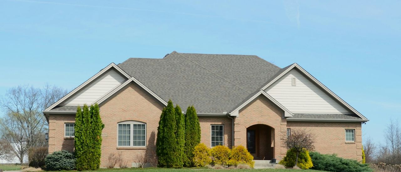 Suburban brick house with a well-kept lawn