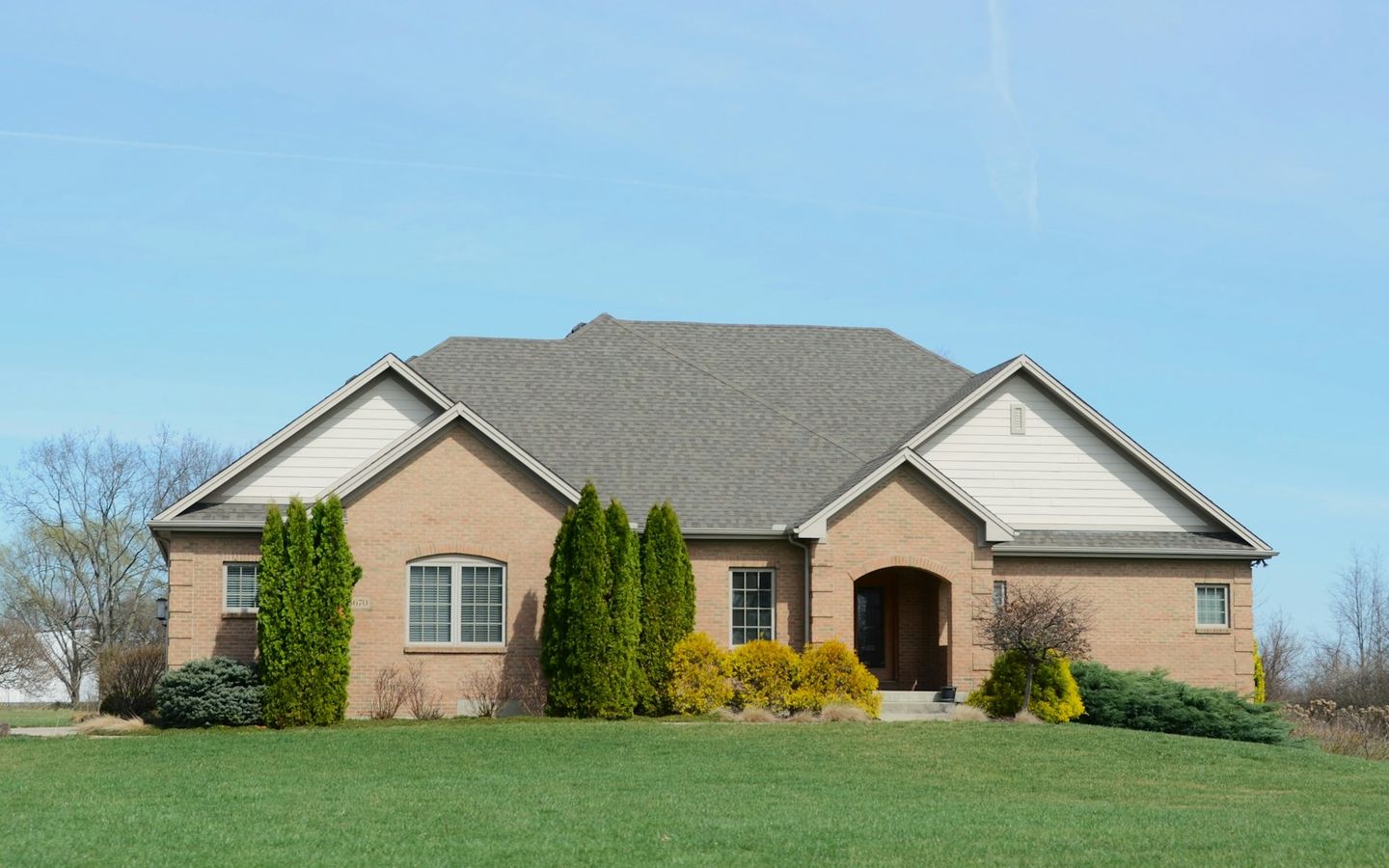 Suburban brick house with a well-kept lawn