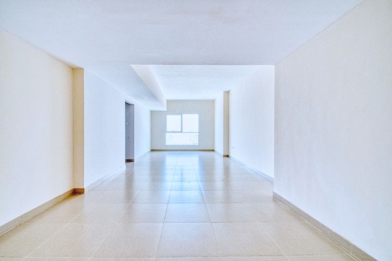 Empty hallway with natural light at the far end
